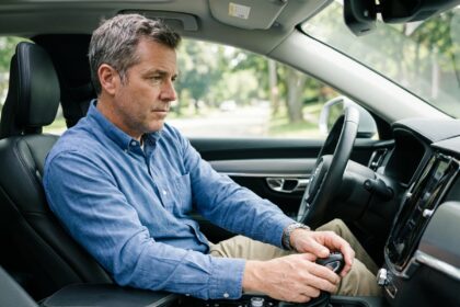 Homme d'âge moyen conduisant une voiture moderne en intérieur