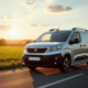 Voiture Peugeot Partner Tepee argentée en campagne au coucher du soleil